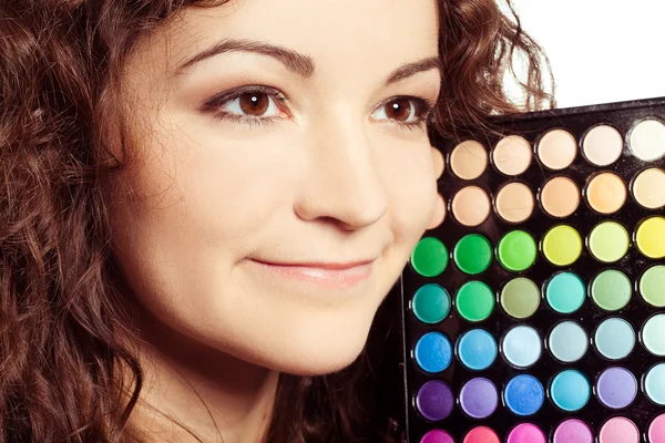 Menina bonita com paleta de sombra multicolor — Fotografia de Stock