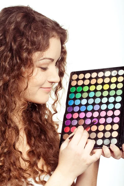 Menina bonita com paleta de sombra multicolor — Fotografia de Stock