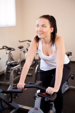 spor salonunda egzersiz bisikleti üzerinde güzel bir kadın
