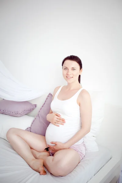Giovane donna incinta in camera da letto — Foto Stock