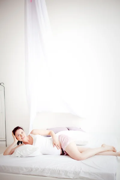 Giovane donna incinta in camera da letto — Foto Stock
