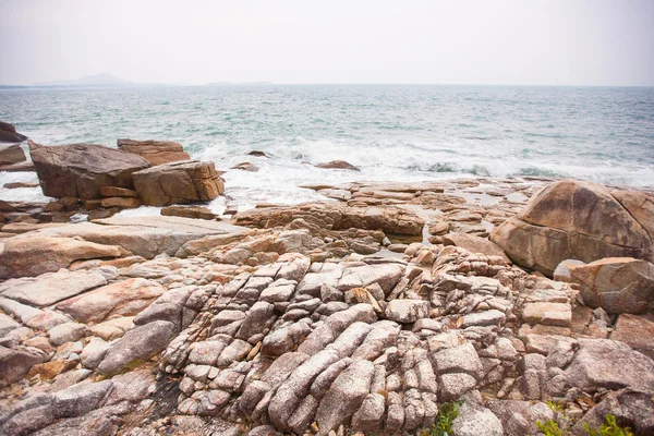 Golven op de rotsen bij kust — Stockfoto