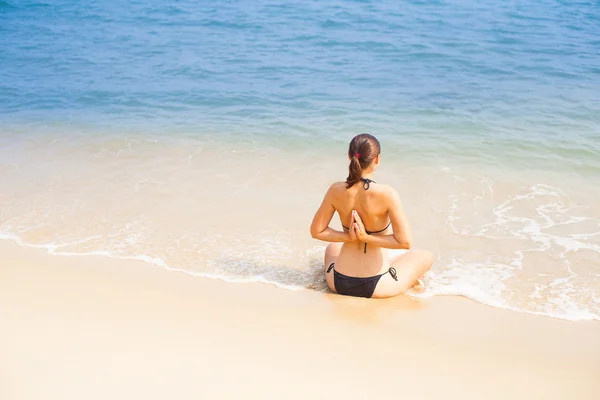 Donna caucasica che pratica yoga sulla spiaggia — Foto Stock