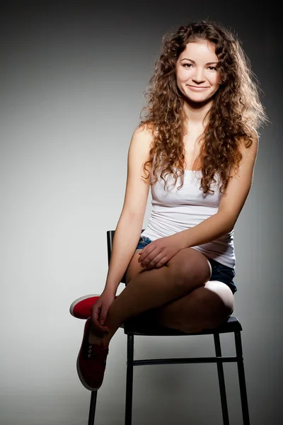Portret van jonge mooie vrouw zittend op stoel — Stockfoto