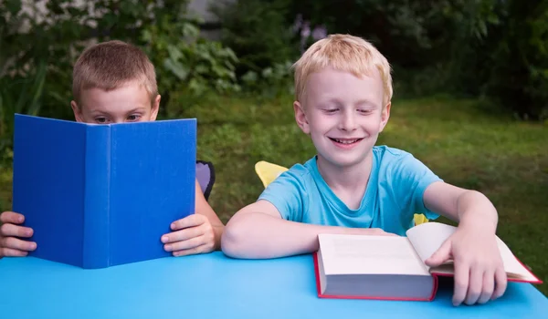 Kitap okuma ve gülümseyerek 8 yıl ve 6 yaşındaki erkek — Stok fotoğraf