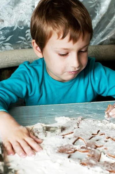 Young boy making and tasting christmas cookies — Stock Photo, Image