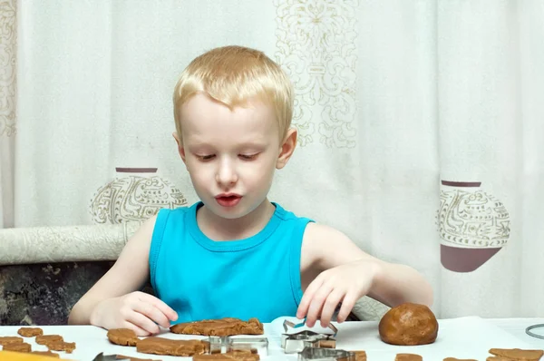 Boy cutting gingerbread dough — Stock Photo, Image