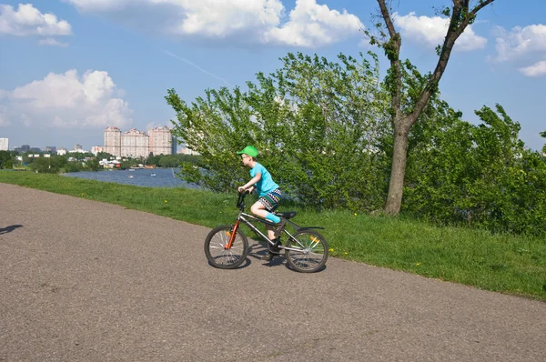 Mooie jongen fietsen in het park — Stockfoto