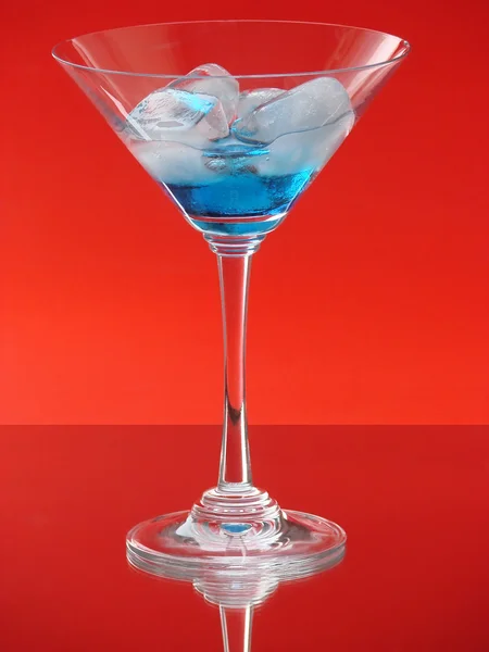 Martini glass with ice on red — Stock Photo, Image
