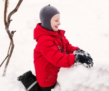 boy gülümseyerek kardan adam yapma.
