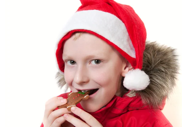 Sonriente chico comiendo pan de jengibre hombre . —  Fotos de Stock