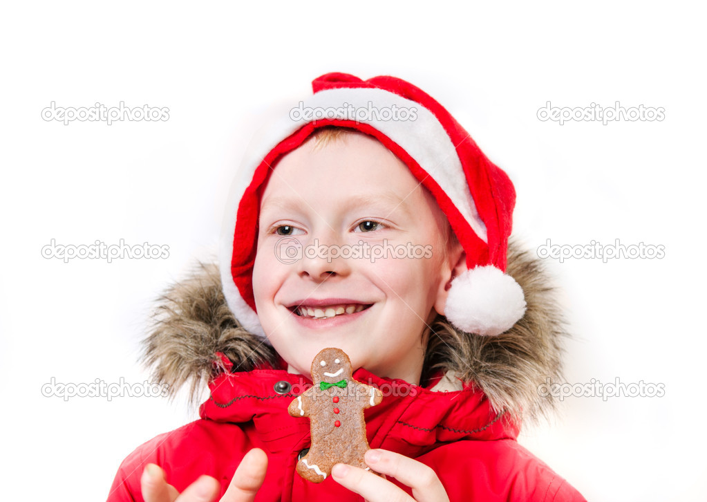 Smiling boy holding gingerbread man.