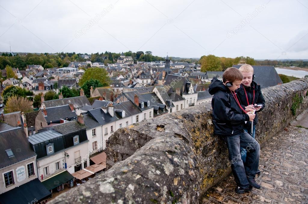 Two boys listening audio guide and discussing at Amboise castle