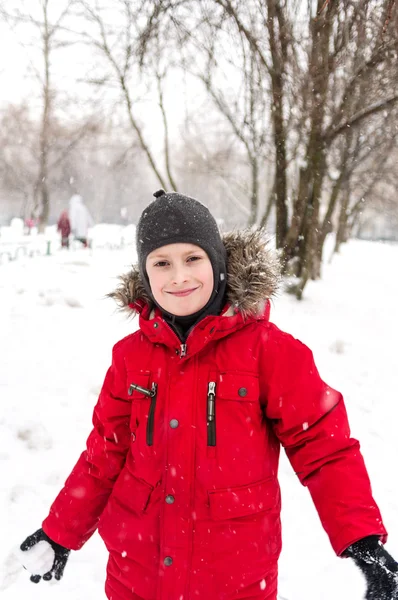 Sorridente ragazzo giocare con la neve — Foto Stock