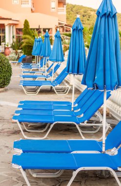 azul de tumbonas y sombrillas en la piscina
