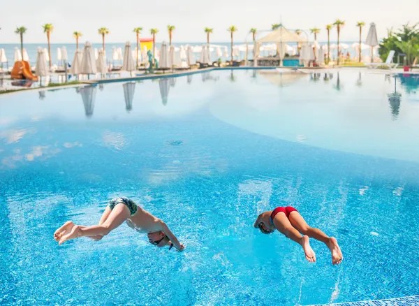 Two boys diving into a pool — Stock Photo, Image