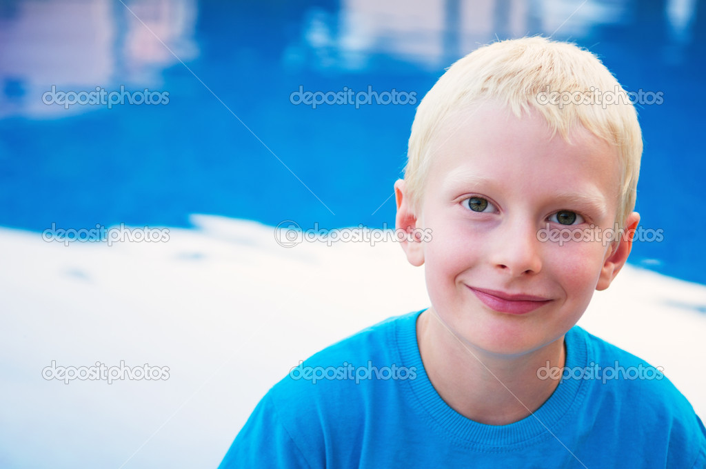 Portrait of young smiling boy at the pool