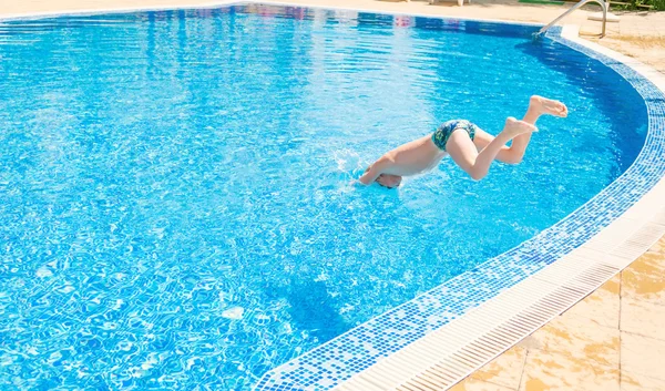 Young boy jumping into swimming pool — Stock Photo, Image