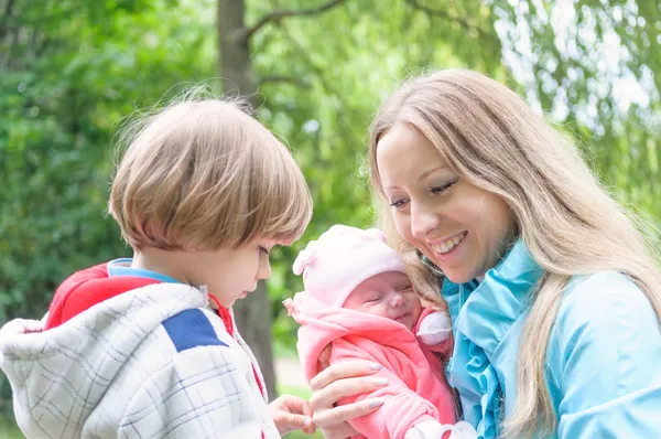 Young mother with her kids in the park. — Stock Photo, Image