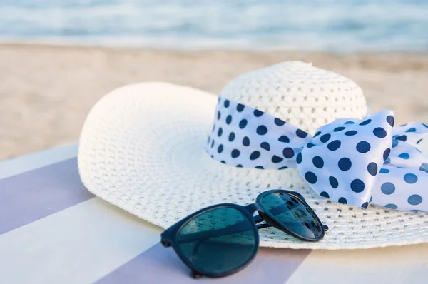 Chapéu e óculos de sol na praia — Fotografia de Stock
