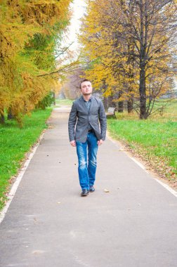 sonbahar parkta yürüyen genç adam