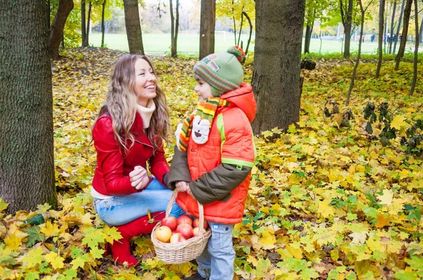 Famiglia felice sorridente e tenendo foglie autunnali — Foto Stock