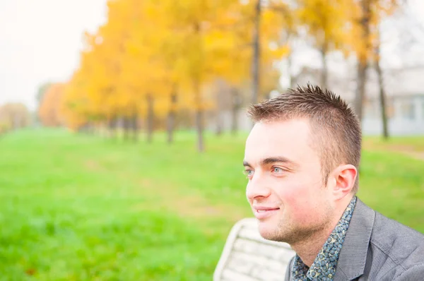 Portret van een jonge man in herfst park — Stockfoto