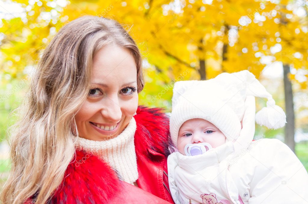 Happy mother and baby in autumn park