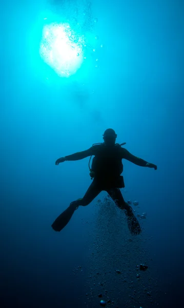 Silhouette of diver with sun disk behind — Stock Photo, Image