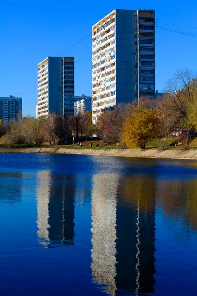 秋には、チェルタノーヴォ yuzhn で池にミラーリングのアパートの建物 — ストック写真