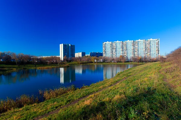 Mehrfamilienhäuser spiegeln sich im Teich im Herbst, chertanovo yuzhn — Stockfoto
