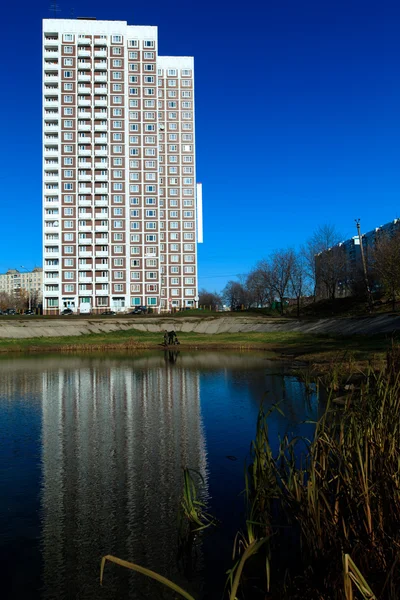 Apartment buildings mirrored in pond at autumn, Chertanovo Centr — Stock Photo, Image