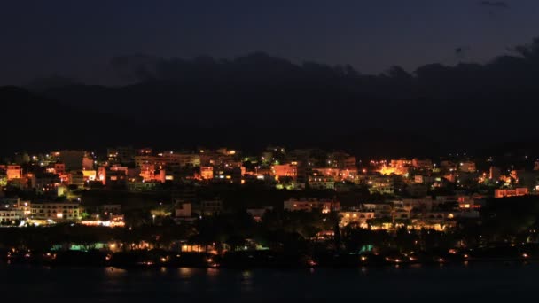 Vista nocturna de la ciudad de Agios Nikolaos a través de la bahía, Creta — Vídeo de stock
