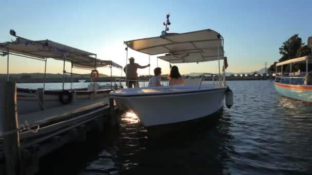 Silhouet van jonge paar in de boot tijdens zonsondergang, corfu, Griekenland — Stockvideo