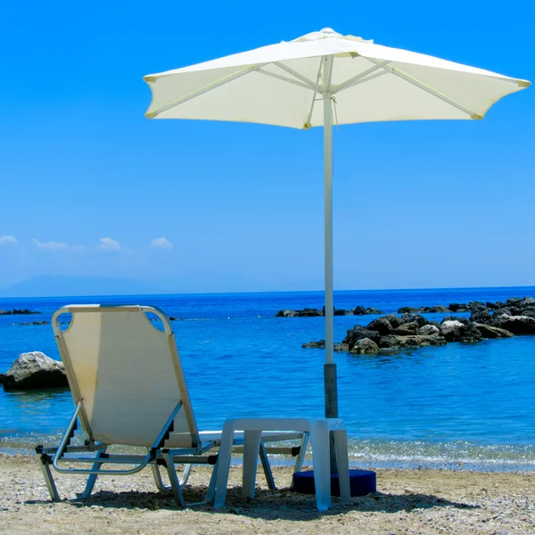 Espreguiçadeira e Parasol em uma praia — Fotografia de Stock