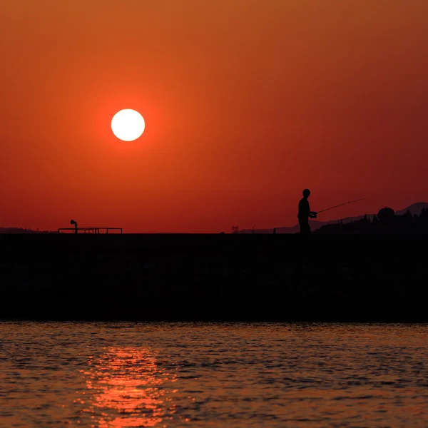 Pôr do sol cena com pescador — Fotografia de Stock