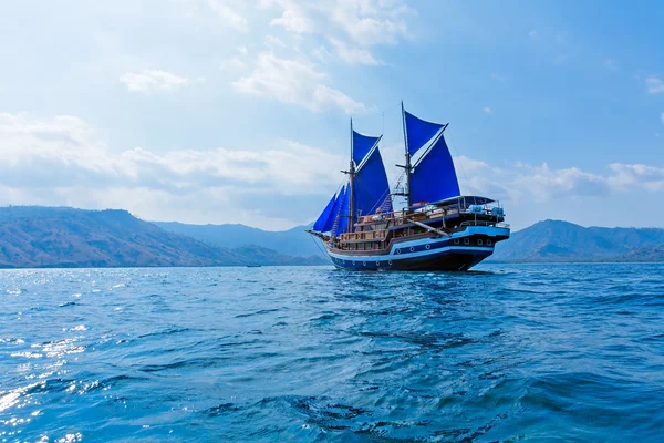 Navio de madeira vintage com velas azuis — Fotografia de Stock