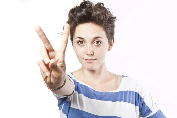 Beautiful young girl making a victory sign isolated over white background — Stock Photo, Image