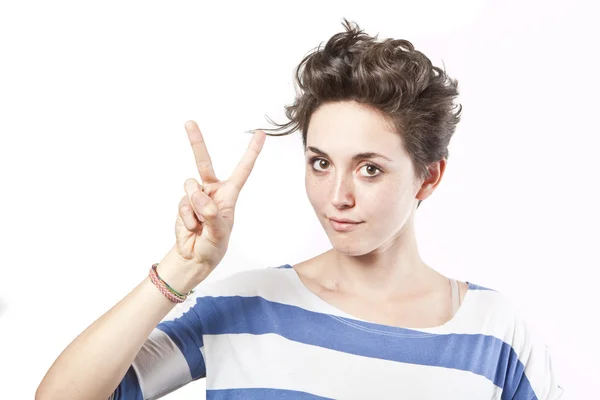 Beautiful young girl making a victory sign isolated over white background — Stock Photo, Image