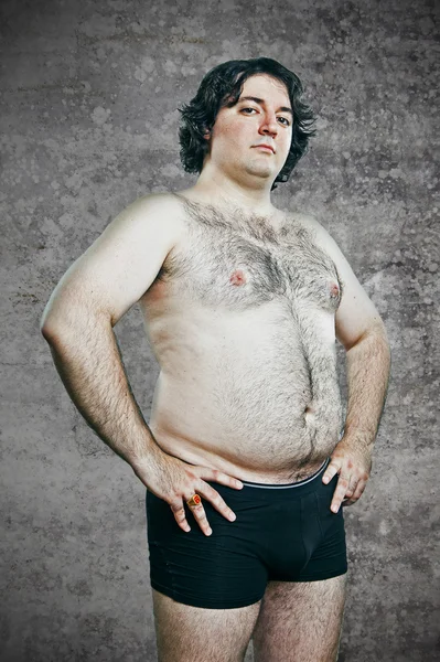 Fat young man over cement background — Stock Photo, Image