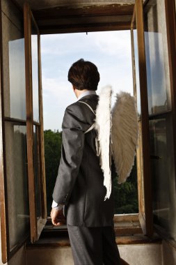 Pencereden bakarak angel wings ile işadamı