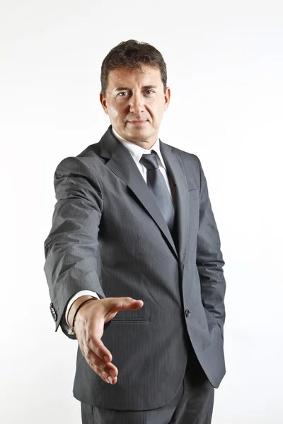 Retrato de um homem de negócios oferecendo uma mão acolhedora isolado no fundo branco — Fotografia de Stock