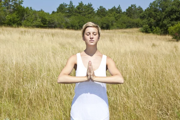 Mujer joven practicando yoga al aire libre — Foto de Stock