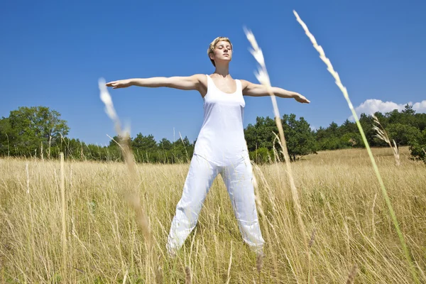 Mujer joven practicando yoga al aire libre — Foto de Stock