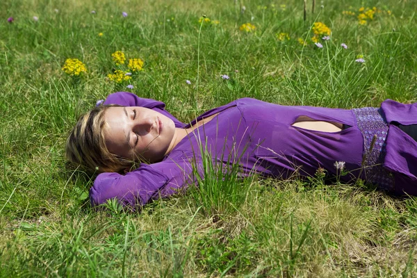 Jong meisje opleggen op het gras — Stockfoto