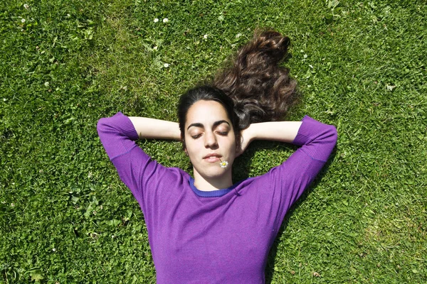 Menina jovem relaxante na grama — Fotografia de Stock