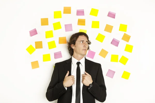 Jeune homme d'affaires avec postit notes de rappel sur le fond — Photo