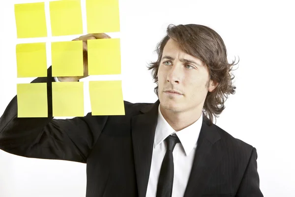 Young businessman looking at postit reminder notes — Stock Photo, Image