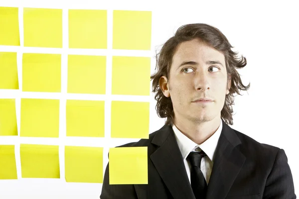 Young businessman looking at postit reminder notes — Stock Photo, Image