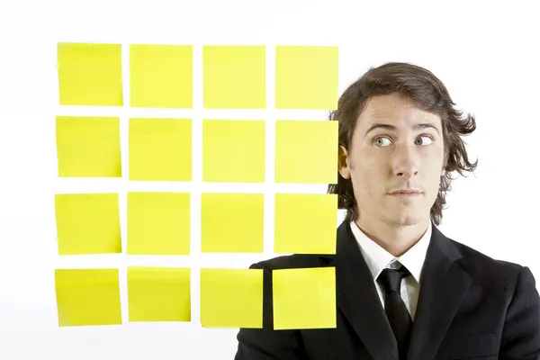 Joven hombre de negocios mirando notas recordatorio postit —  Fotos de Stock